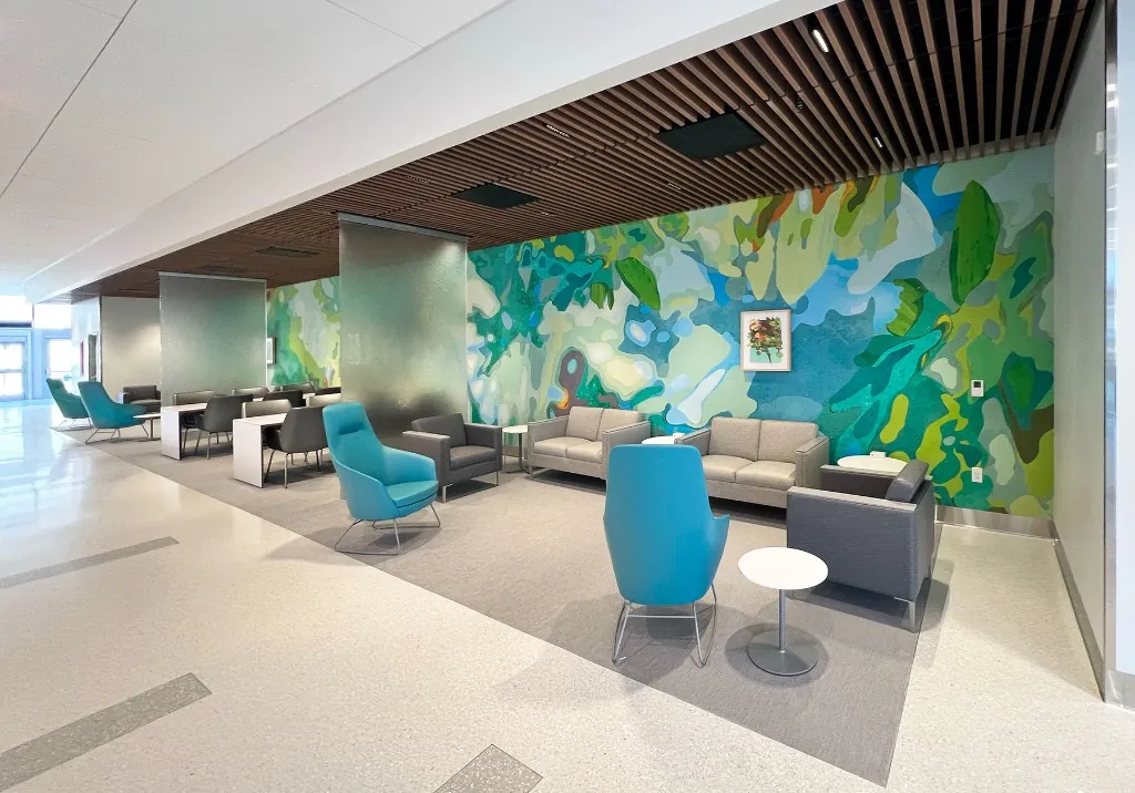 Vibrant green abstract mural wrapping a UC San Diego Health waiting lounge.
